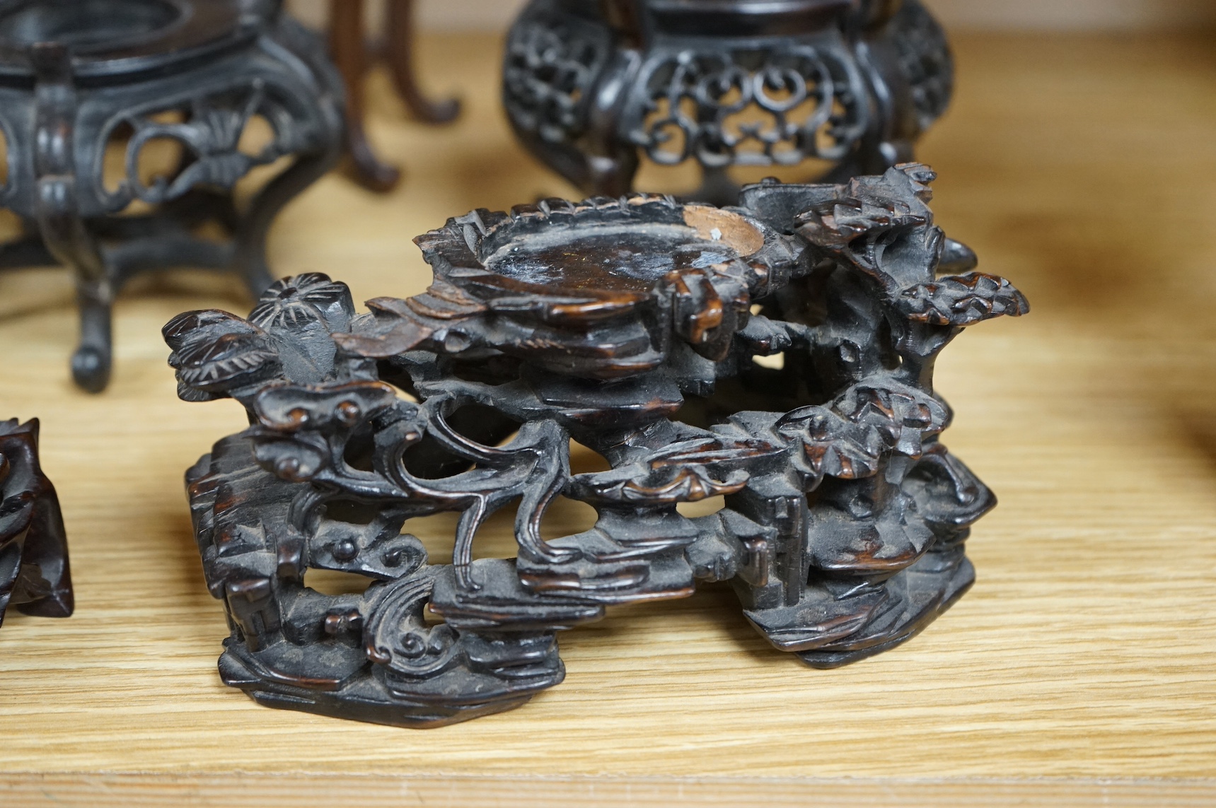 A collection of fifteen Chinese and Japanese carved hardwood stands, tallest 15.5cm. Condition - fair to good
